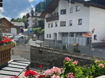 Ein Balkon mit Blumen und Blick auf das Dorf