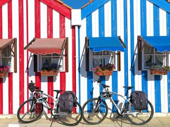 Räder vor bunten Strandhütten am Atlantik