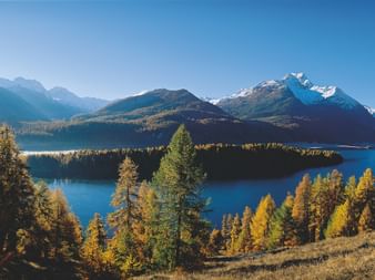 Le lac de Sils en automne se trouve au milieu d'un paysage de montagne recouvert de neige.