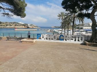 Blick Schriftzug Porto Cristo und auf den Hafen und das Meer von Porto Cristo.