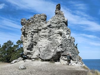 Ein Mann klettern auf einer 10 Meter hohen Kalksteinsäule auf Gotland.