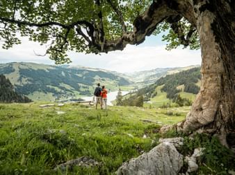 A couple of hikers take a break and enjoy the wonderful view at Schwarzsee near Fribourg.