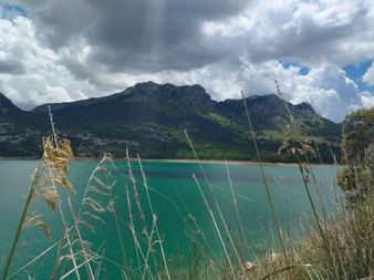 Meeresbucht mit türkisfarbenem Wasser. Im Hintergrund Berge.