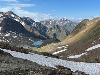 Ein Bergtal mit einem See und Gletscher im Hintergrund