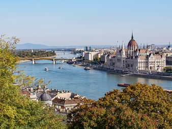 Parlamentsgebäude in Budapest von der Höhe fotografiert. Im Vordergrund die Donau.