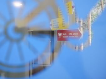 Glasfenster des Eurotrek-Büros in Dietikon mit rotem WLAN-Aufkleber mit Netzwerkname und Passwort. Fahrrad-Logo durch Glas sichtbar.