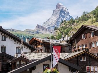 Traditionelle Schweizer Chalets in Zermatt mit dem ikonischen pyramidenförmigen Matterhorn Gipfel im Hintergrund.