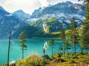 Wanderer am türkisblauen Bergsee Oeschinensee mit Bergpanorama im Hintergrund