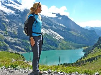 Hiker in front of Lake Oeschinen in Switzerland