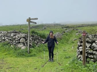 Riana steht nebene einer Steinmauer auf El Hierro, welche an die Hadrians Wall in Schottland erinnert.
