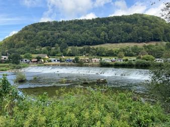 Ein kleiner Wasserfall liegt am Ufer des Doubs in der Nähe von Saint-Ursanne.