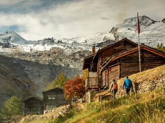 Mountain huts near Saas Fee are visited by a hiking couple.