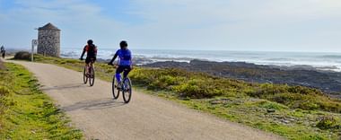 Radfahrer an der Küste im Hintergrund das Meer.