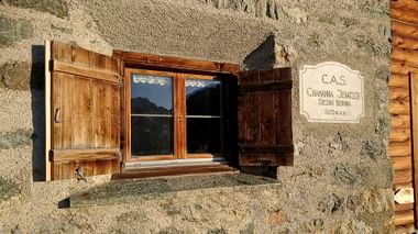 Ein Fenster mit Holzrahmen der Jenatsch Hütte in Bernina im Kanton Graubünden.