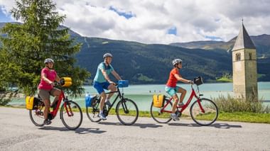 Radfahrer am versunkenen Kirchturm am Reschensee
