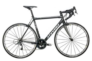 Schwarzes Stevens Aspin Rennrad mit Rennlenker, dünnen Reifen und Renngeometrie im Profil vor weißem Hintergrund.