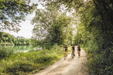 Drei Radfahrer neben einem Fluss