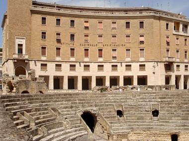 Das Institut der nationalen Versichherungen vor Ruinen eines Amphitheaters aus dem römischen Reich.