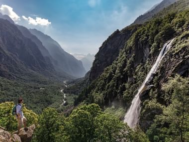 Wanderer bewundert den Wasserfall Foroglio