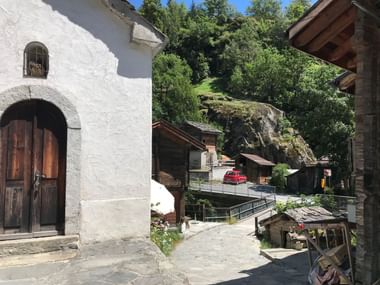 Holzhäuser umgeben von Felsen und Bäumen im Kanton Wallis