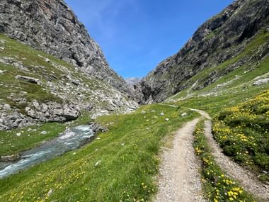 Ein Wanderweg führt entlang einer Felswand mit Aussicht