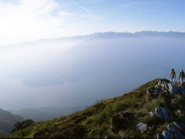 Wanderer mit einer vernebelten Aussicht auf den Luganersee. Sentiero Lago di Lugano. Wanderferien mit Eurotrek.