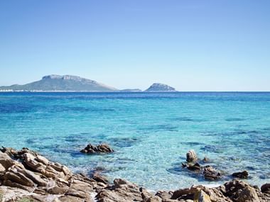 Kristallklares Wasser an der Küste auf Sardinien mit Blick auf das offene Meer.