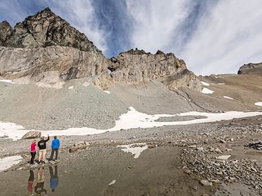 Plusieurs randonneurs admirent le sommet d'une montagne.