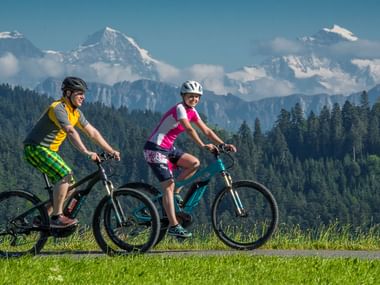 Zwei Mountainbiker auf einer gemütlichen Fahrt vor der Berglandschaft.