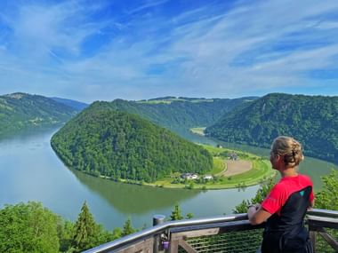 Eine Radfahrerin genießt den Blick auf die Schlögener Schlinge