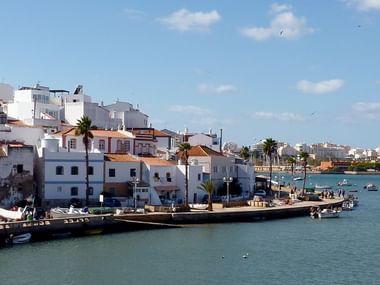 Promenade von Ferragudo mit vielen kleinen Booten auf dem Wasser.