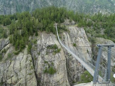 Eine Hängebrücke führt über eine schmale Schlucht mit steilen Wänden.