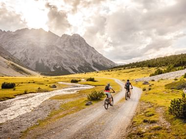 Zwei Mountainbikefahrer auf einem Weg inmitten karger Naturlandschaft.
