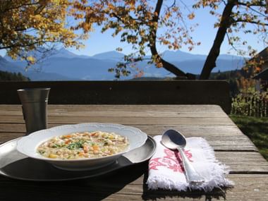 Ein Suppenteller mit Suppe steht auf einem Tisch in Südtirol.