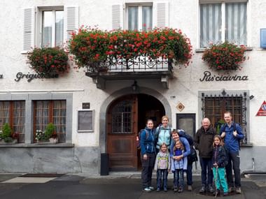 Eine Familie steht vor einem Hotel in Bernina