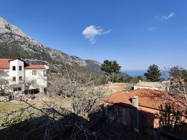 Zwei Häuser am Hang vor einer Berg und Meer Kulisse