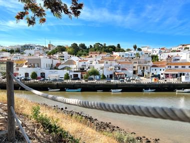 Ausblick auf Fischerdorf an der Algarve mit weißen Häusern und blauem Himmel