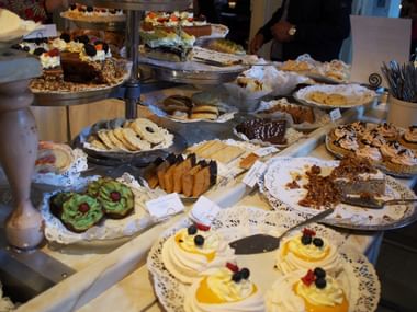 Üppiges Dessertbuffet mit verschiedenen schwedischen Gebäckstücken, Kuchen und Keksen auf Etageren und Tellern in einem Café in Mariefred.