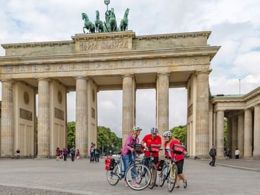 Drei Radfahrer vor dem Brandenburger Tor in Berlin