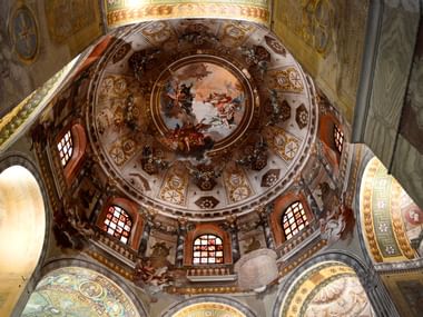 Die Basilika in Ravenna ist von rot-weissem Mosaik bedeckt und die Kuppel verziert.