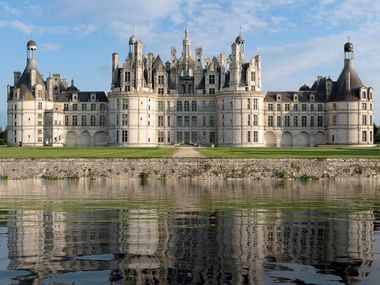 Der Ausschnitt des Schloss Chambord im Loire-Tal in Frankreich. Im Vordergrund ist die Loire zu sehen.