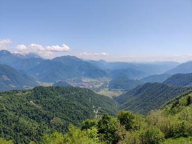 Ausblick ins Tal und über viele bewaldete Berge.