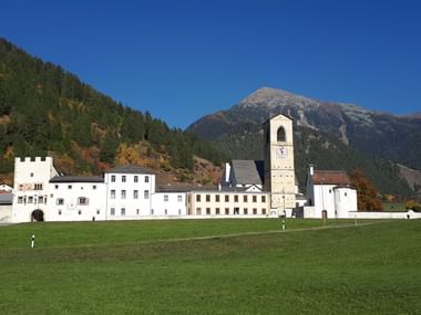Ein Kloster thront vor einem Berg.