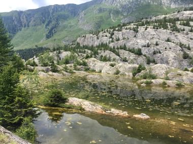 See mit einer steinigen Landschaft im Hintergrund. Aletsch-Panoramaweg. Wanderferien mit Eurotrek.