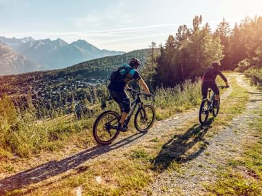 Zwei Velofahrer auf einer Naturstrasse im Wallis.