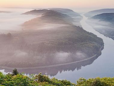 Unter Nebligem Himmel verläuft die Saarschleife an der Mosel.