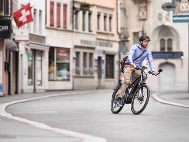 Velofahrer auf einer Strasse in der Schweiz. Rent a Bike Langzeitmiete.