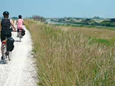 Radweg mit zwei Radlern durch die venezianische Landschaft
