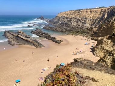Sandstrand mit Felsen und Badegästen