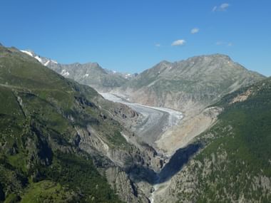 Der Aletschgletscher zwischen den Bergen und unter schönem blauen Himmel.
